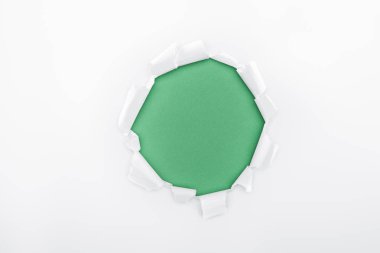 torn hole in white textured paper on green background  clipart