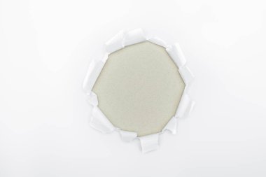 torn hole in white textured paper on grey background  clipart