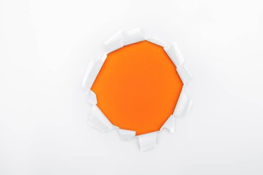 torn hole in white textured paper on orange background  clipart