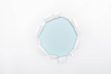 torn hole in white textured paper on light blue striped background  clipart