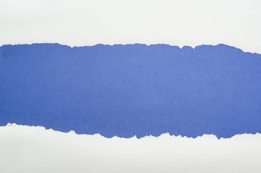 ragged white textured paper with copy space on deep blue background 