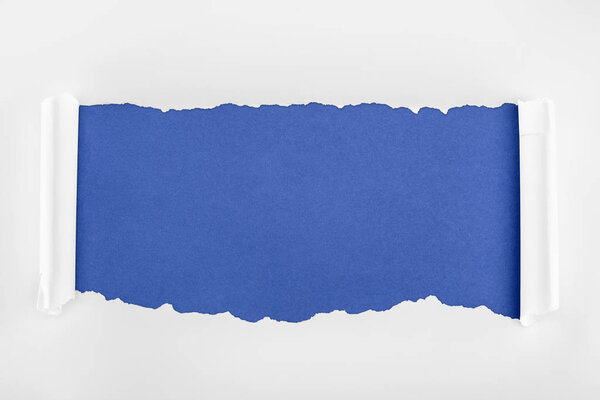 ragged textured white paper with curl edges on blue background 