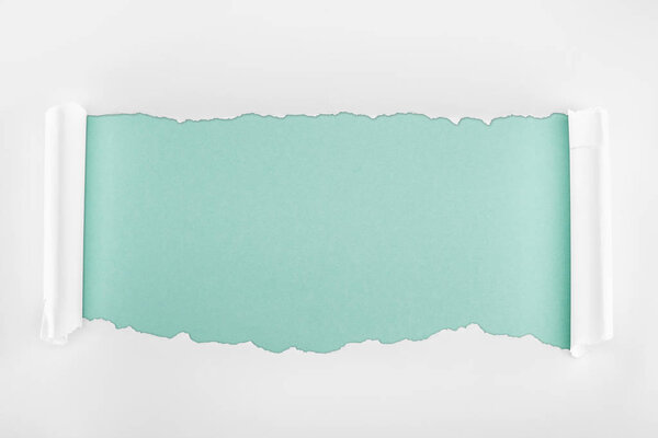 ragged textured white paper with curl edges on light blue background 