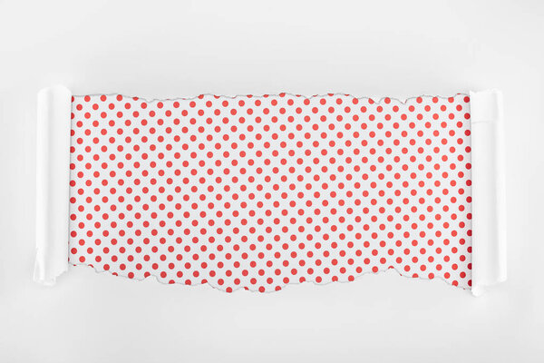 разорванная белая текстурированная бумага с загнутыми краями на красном пунктирном фоне
 