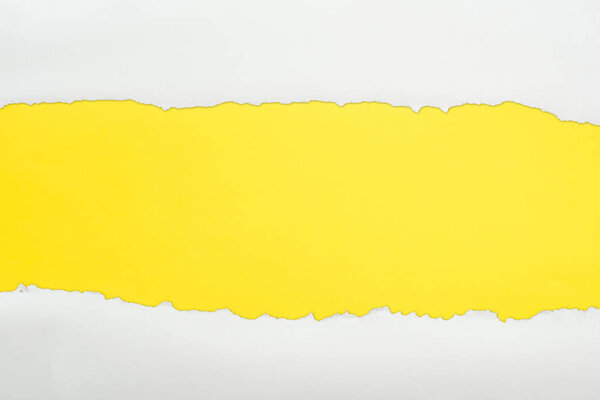 ripped white textured paper with copy space on yellow background 