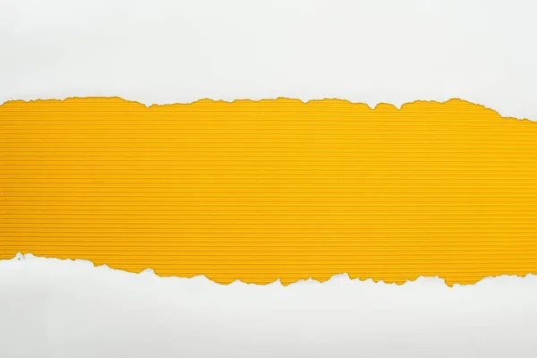 ripped white textured paper with copy space on yellow striped background