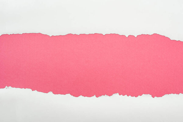 ragged white textured paper with copy space on pink background 