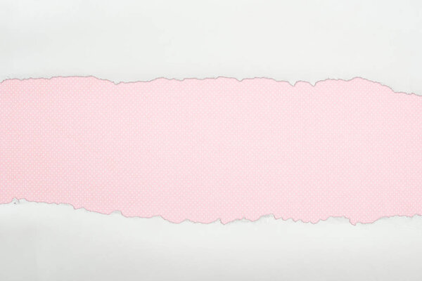 ragged white textured paper with copy space on pink background 