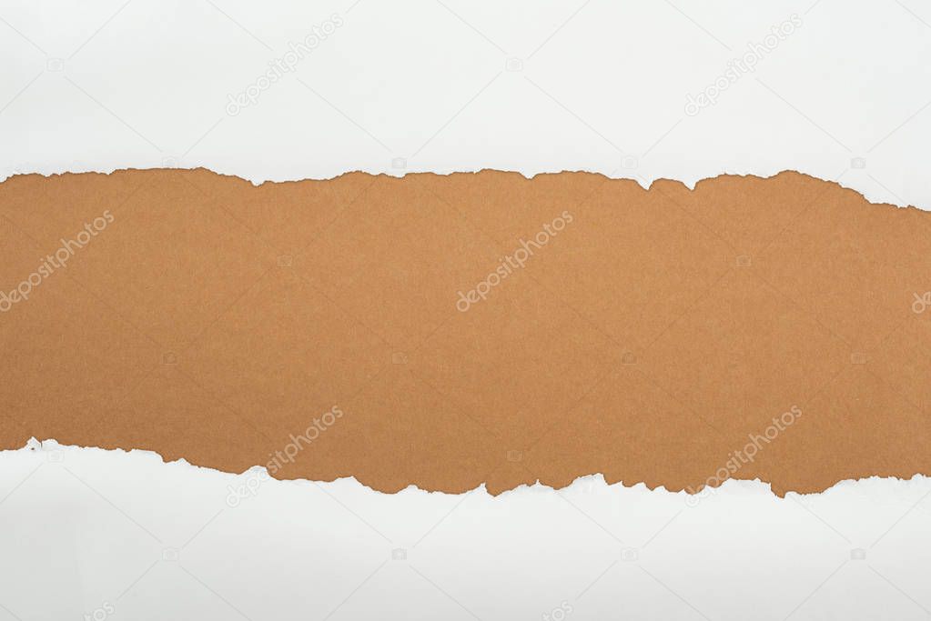 ragged white textured paper with copy space on brown background 