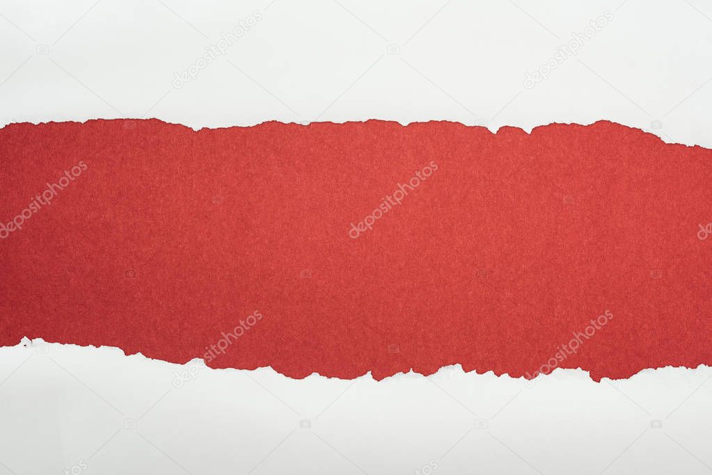 ragged white textured paper with copy space on burgundy background 