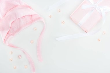 pembe hediye kutusu ve kaput üst görünümü, beyaz arka planda inciler 