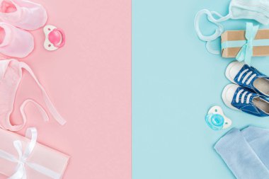 pembe ve mavi arka planda emzikler, hediyeler, şapka, Booties, spor ayakkabıları, kaput üst görünümü