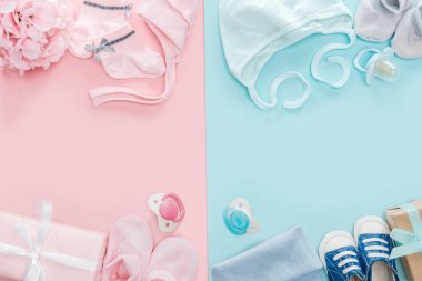 top view of pacifiers, gifts, hat, booties, bonnets, sneakers, socks, bouquet on pink and blue background  clipart