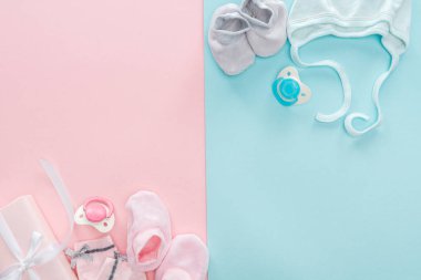 pembe ve mavi arka planda emzik, hediye, Booties, Bonnet, çorap üst görünümü