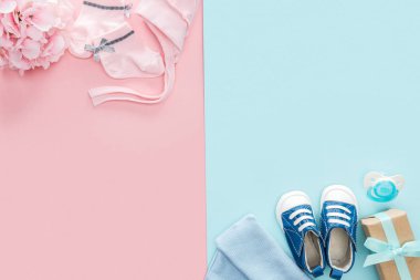 pembe ve mavi arka planda emzik, hediye, şapka, kaput, spor ayakkabıları, çorap, buket üst görünümü 
