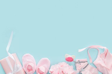mavi arka planda emzik, hediye, Booties, Bonnet, çorap ve buket üst görünümü