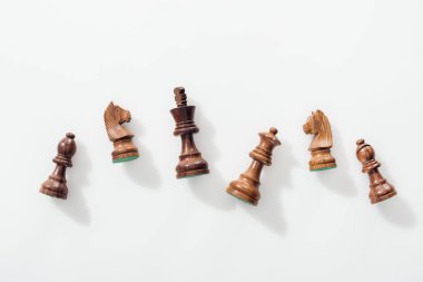 Beyaz arka plan üzerinde yukarıdan ahşap kahverengi satranç figürleri
