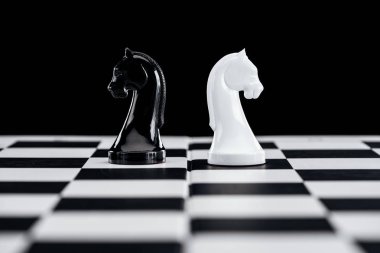 satranç tahtası seçici odak ve siyahta izole siyah ve Beyaz Şövalyeler