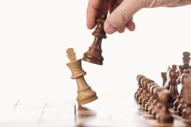Kraliçe Kral yakınındaki beyaz izole ahşap satranç tahtası üzerinde tutan adamın kısmi görünümü