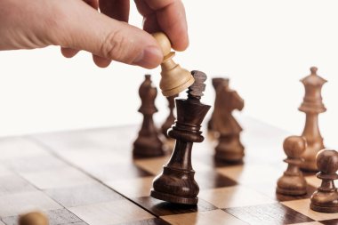 piyon ahşap satranç tahtası üzerinde beyaz izole yukarıda tutan adamın kısmi görünümü