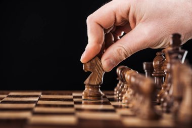 yapan erkek görünümünü kırpılmış ahşap satranç tahtası üzerinde siyah izole knight ile hareket
