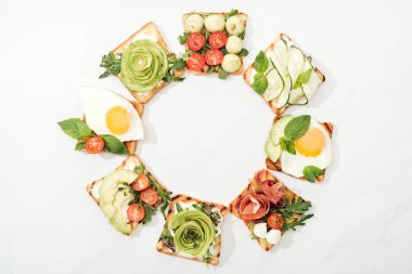 Tost kesilmiş sebzeler, kızarmış yumurta ve jambon ile üstten görünüm beyaz yüzeyi