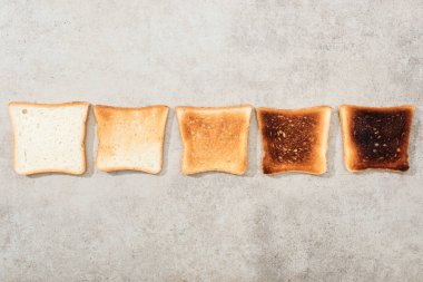 Top view of bread toasts on grey textured surface clipart