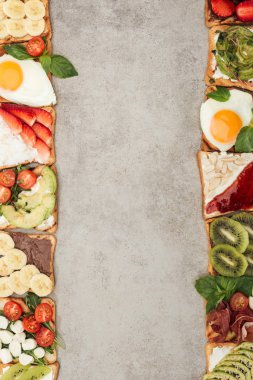 Kızarmış yumurtalı tost görünümünü top, sebze ve meyve dokulu yüzey üzerinde kesmek
