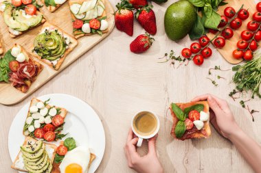 kahve masasında görmek malzemeler, yeşillik ve tost ile sebze ve prosciutto tutan kadın Üstten Görünüm