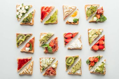 top view of delicious toasts with fruits and vegetables isolated on white clipart