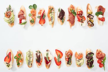 jambon, somon, meyve, sebze ve otlar ile geleneksel İtalyan bruschetta üstten görünüm beyaz kopya alanı ile