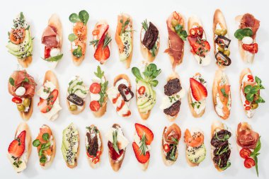 lezzetli İtalyan bruschetta somon, prosciutto, kurutulmuş domates, avokado, çilek ve otlar üzerinde beyaz arka plan