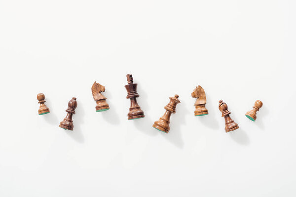 top view of wooden chess figures on white background