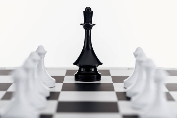 селективный фокус шахматной доски с фигурой черной королевы среди белых пешек, изолированных на белом

