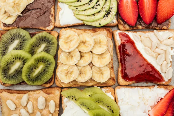 Draufsicht Auf Toasts Mit Geschnittenen Früchten Beeren Und Erdnüssen — Stockfoto