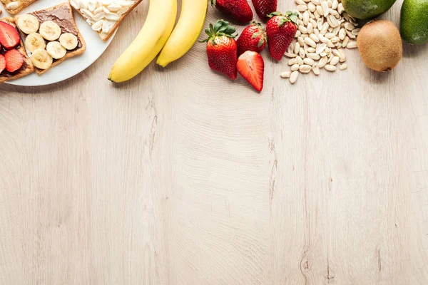 Top View Bananas Strawberries Peanuts Toasts Wooden Table Copy Space — Stock Photo, Image