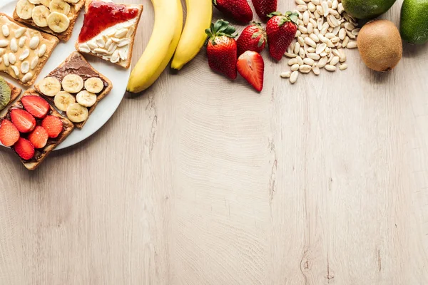 Top View Bananas Strawberries Peanuts Toasts Wooden Table Copy Space — Stock Photo, Image