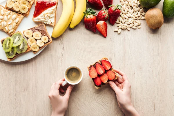 Vista Superior Mujer Sosteniendo Taza Café Sobre Mesa Madera Con — Foto de Stock