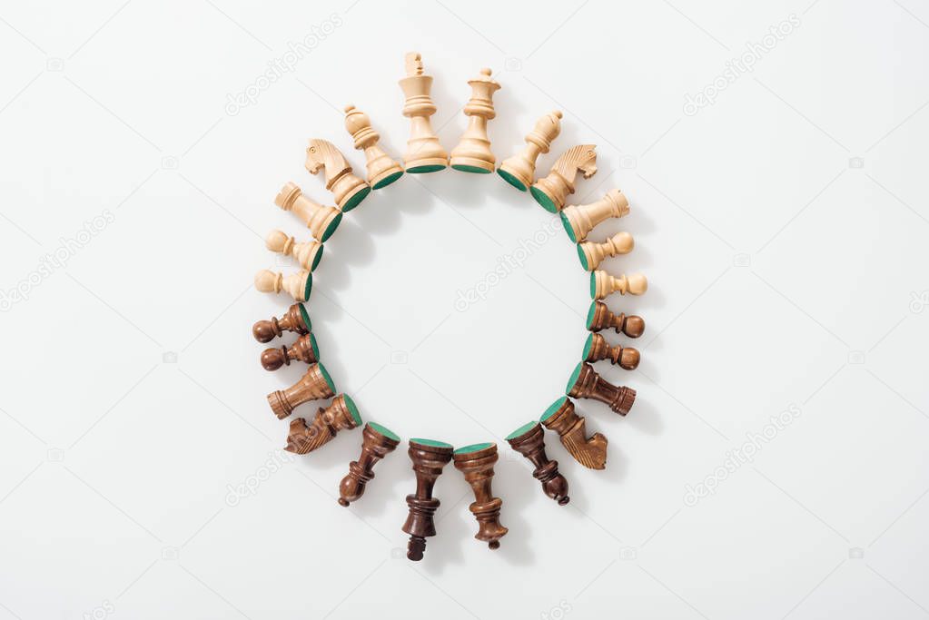 top view of round frame made of wooden chess figures on white background