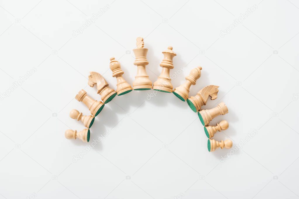 top view of semicircle made of wooden chess figures on white background