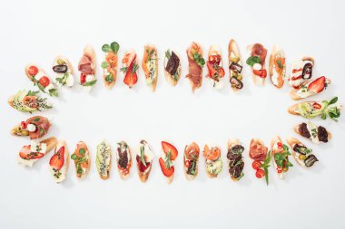 jambon, somon, meyve, sebze ve otlar ile düzenlenmiş İtalyan bruschetta üstten görünüm beyaz