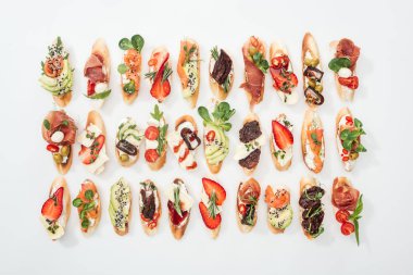 geleneksel İtalyan bruschetta somon, prosciutto, kurutulmuş domates, avokado, çilek ve otlar üzerinde beyaz arka plan