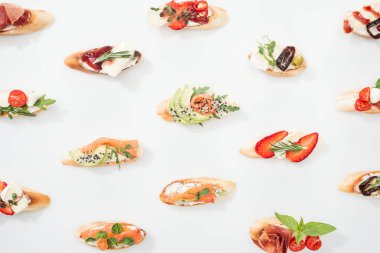 background of italian bruschetta with salmon, prosciutto, avocado, strawberries and herbs on white clipart