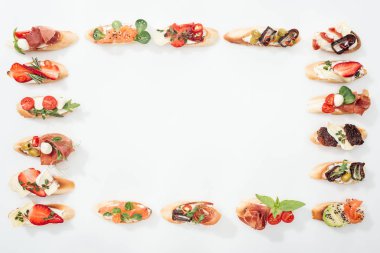 çerçevenin üstten görünüm meyve, sebze ve otlar üzerinde beyaz kopya alanı ile geleneksel İtalyan bruschetta prosciutto, somon, ile yapılmış