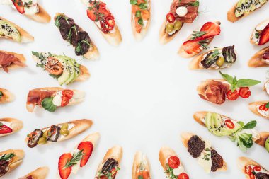 somon, prosciutto, otlar ve çeşitli meyve sebze beyaz ile İtalyan bruschetta yuvarlak çerçevenin üstten görünüm yapılmış