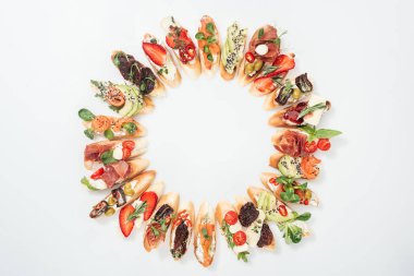 lezzetli İtalyan bruschetta somon, jambon, otlar ve sebze ile çeşitli meyve ile yapılmış yuvarlak çerçevenin Üstten Görünüm