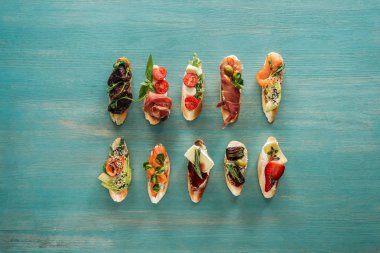 somon, kurutulmuş domates, jambon ve otlar ile İtalyan bruschetta üstten görünüm ahşap tablo