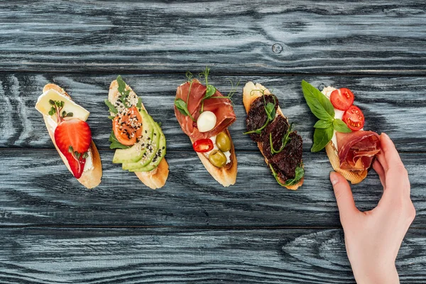 Cropped View Woman Italian Bruschetta Prosciutto Salmon Vegetables Wooden Table — Stock Photo, Image