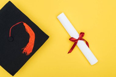 Akademik kap ve diploma sarı izole kırmızı kurdele ile Üstten Görünüm