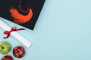 Mavi yüzeyi akademik kap, diploma ve elma Üstten Görünüm